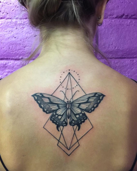 Blackwork butterfly on back with geometric accents by Marked Studios
