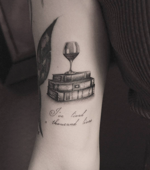 Glass of wine on books by Kane Navasard
