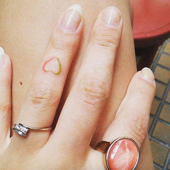 Two-toned heart on finger by Life Ink