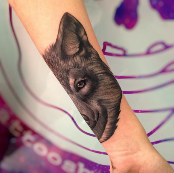 Half wolf tattoo on forearm by Santiago Buriticá