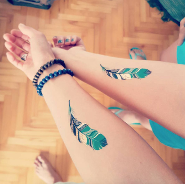 Matching Indian feather tattoos via Popovicka