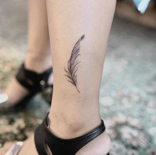 Detailed feather tattoo by Nando