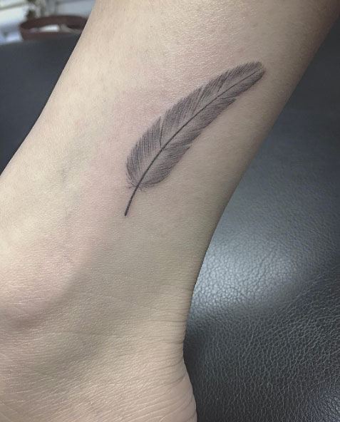 Feather tattoo on ankle by East Iz