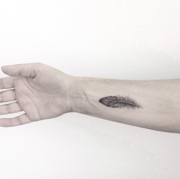 Black and grey ink feather tattoo on wrist by Shpadyreva Julia
