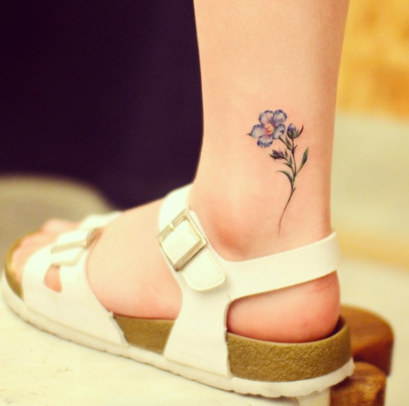 Flax flower ankle tattoo by Grain