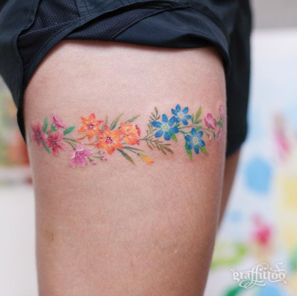 Colorful floral garter tattoo by Tattooist River