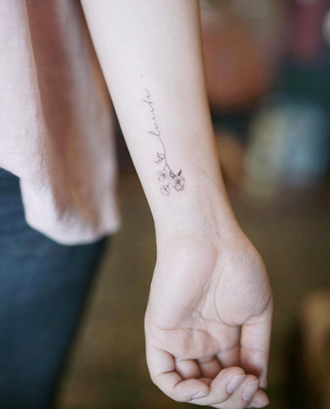Mini floral wrist tattoo by Nando