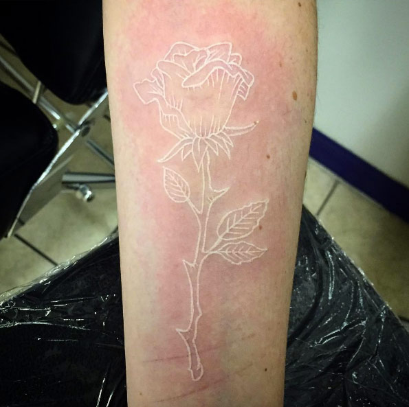 Minimalistic white ink rose tattoo by Michael Manfredi