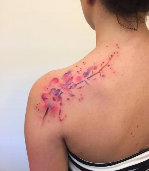 Watercolor orchids on back shoulder by Bora Tattoo