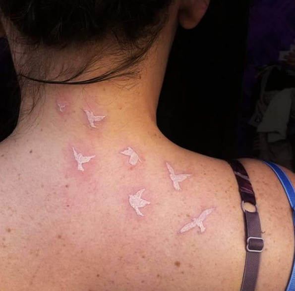 White ink birds on back neck by Dita