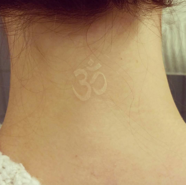 White ink sanskrit symbol on back neck via Denise Steiger