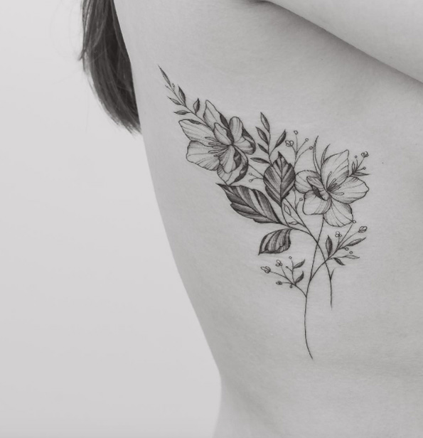 Delicate black and grey ink floral tattoo on rib cage by Tritoan Ly