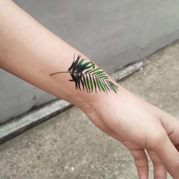 Fern frond tattoo on wrist by Zihee
