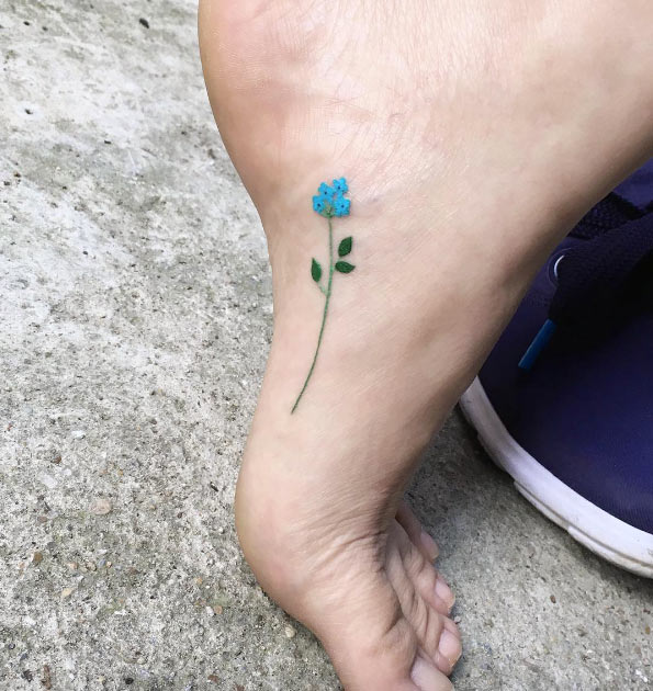 Itty-bitty blue flower tattoo on foot by Zihee