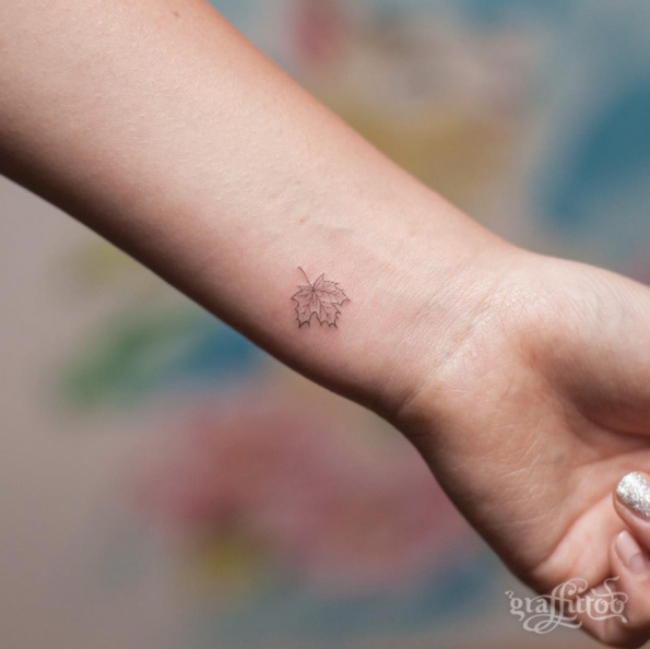 Tiny maple leaf tattoo by Tattooist River