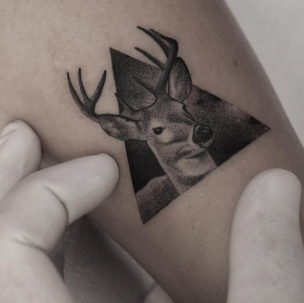 Tiny triangular stag tattoo by Fillipe Pacheco