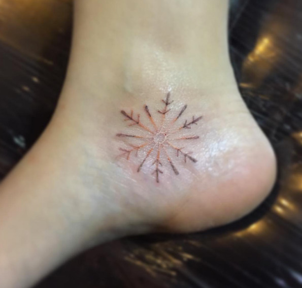 Snowflake tattoo on ankle by Alex Uno