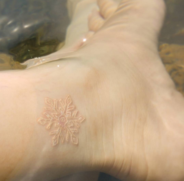 Freshly inked white ink snowflake on ankle via Rosa Maria Alejandra