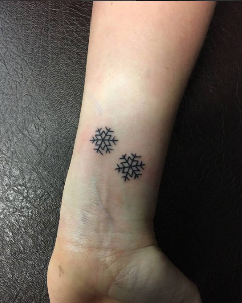 Two tiny snowflakes on wrist by Black Dagger