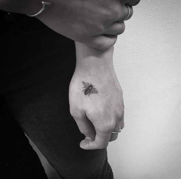 Tiny blackwork bee tattoo by Balazs Bercsenyi