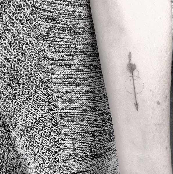 Micro arrow tattoo by Lindsay April