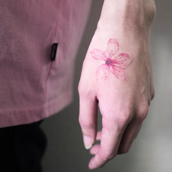Single cherry blossom tattoo on hand by Hongdam