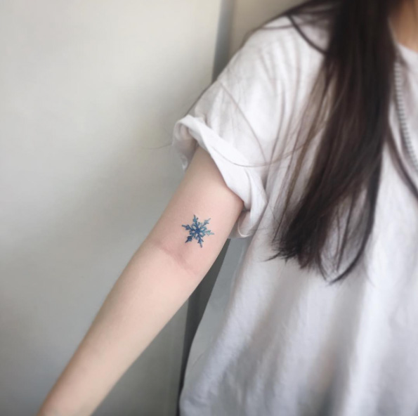 Small watercolor snowflake tattoo by Tattooist Flower