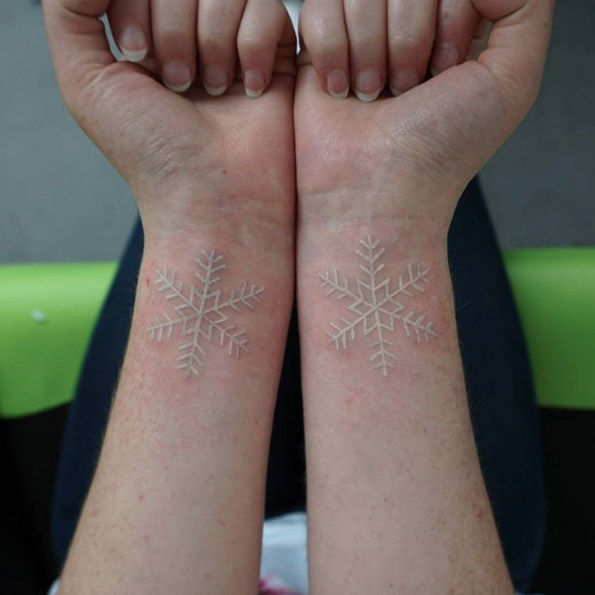 Matching snowflake wrist tats by Kakapo Ink