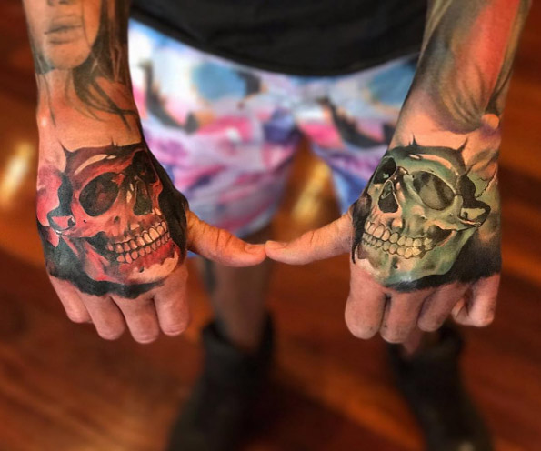 Matching skull tattoos on hands by Benjamin Laukis