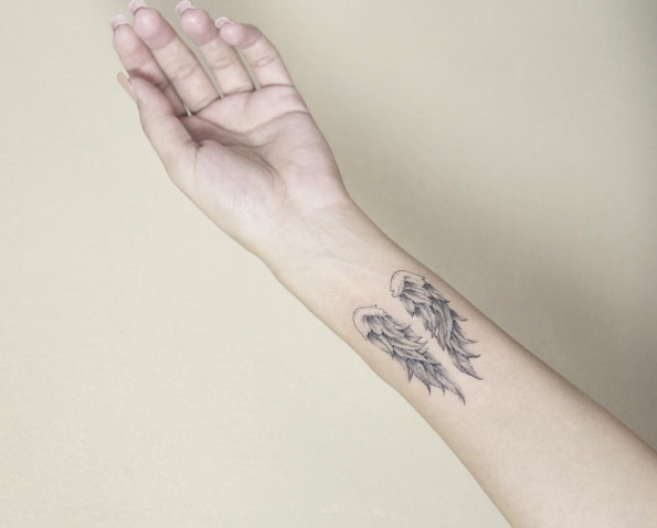 Wings tattooed on wrist by Luiza Oliveira