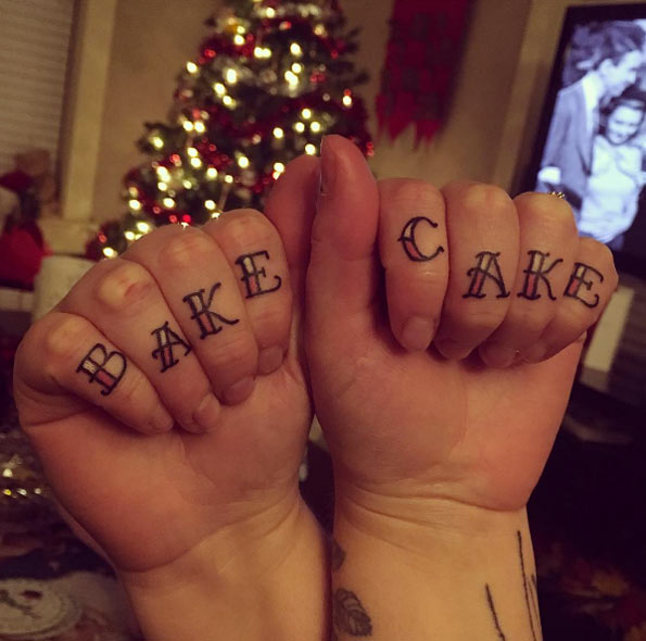 Matching 'bake cake' knuckle tattoos by Dan Cariou