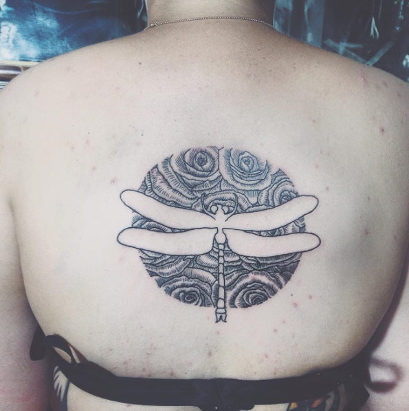 Negative space dragonfly tattoo on back by Atramors