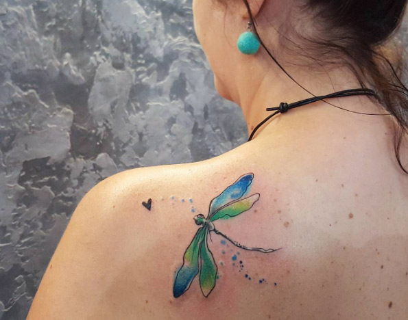 Playful dragonfly tattoo on back shoulder by Simona Blanar