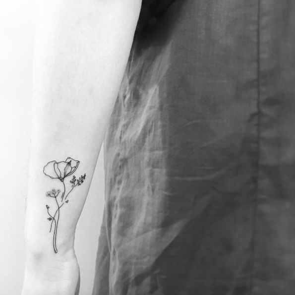Black ink floral tattoo on wrist by OK