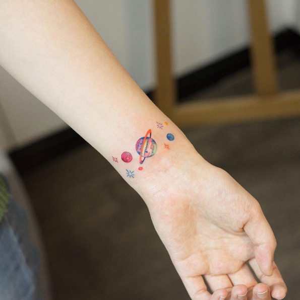 Space-themed wrist tattoo by Zihee