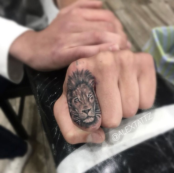 Lion knuckle tattoo by Alex Tattz