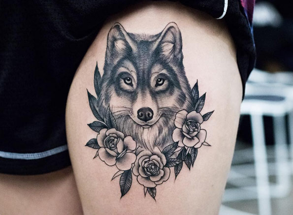 Elegant wolf tattoo on thigh by Kristi Walls