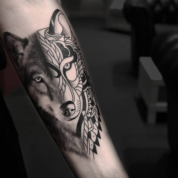 Divided wolf tattoo on forearm by Urban Art