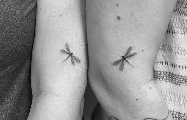 Matching dragonfly tattoos by Carla Galvao