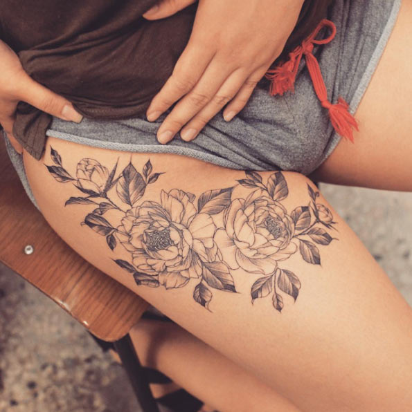 Floral thigh tattoo by Tattooist Grain