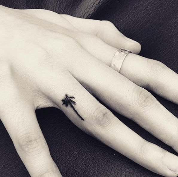 Tiny palm tree tattoo on finger by Ana Baha