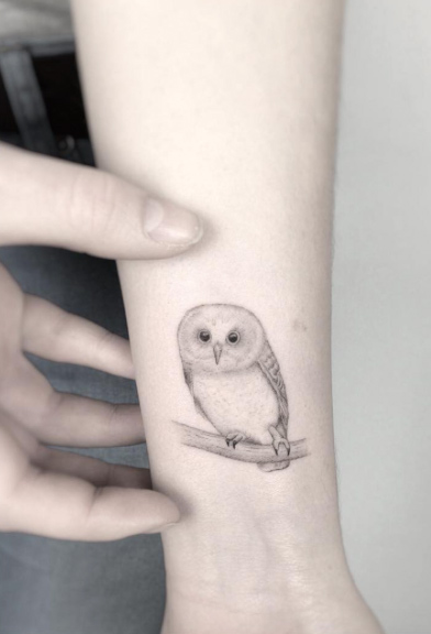 Small owl tattoo on wrist by Jakub Nowicz