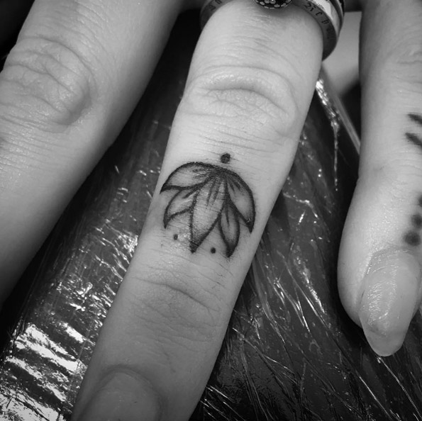 Lotus flower finger tattoo by Clara Welsh