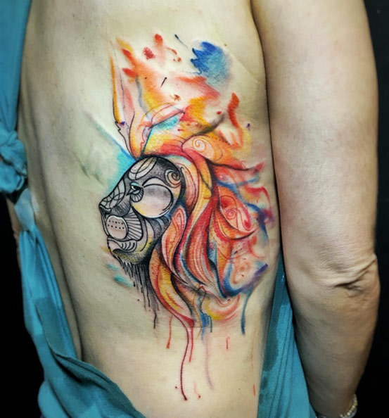Watercolor lion tattoo on rib cage by Alejandra Idarraga