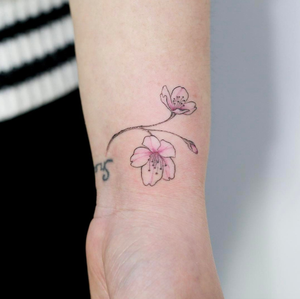 Cherry blossoms on wrist by Tattooist Doy
