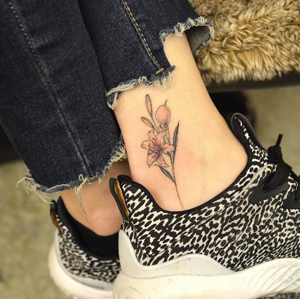Lily flower tattoo on ankle by Tattooist Grain
