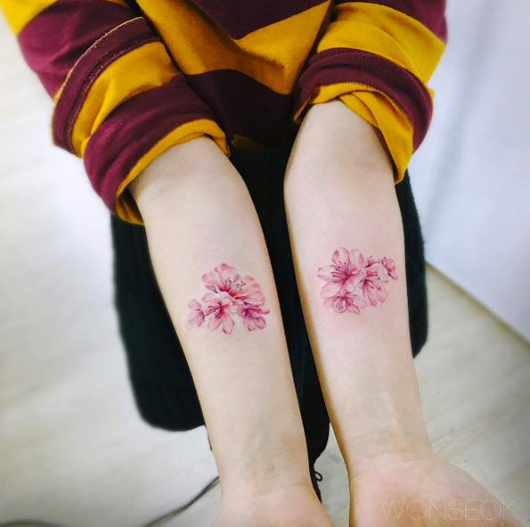 Matching cherry blossom tattoos by Wonseok