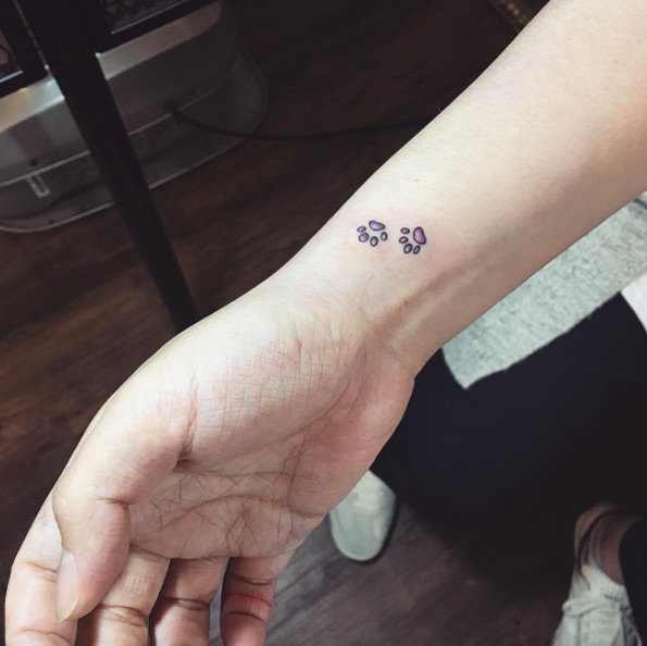 Micro paw print tattoos on wrist by Mojo