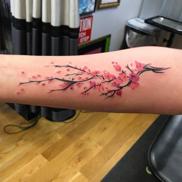 Vibrant cherry blossom tattoo on forearm by John Torres
