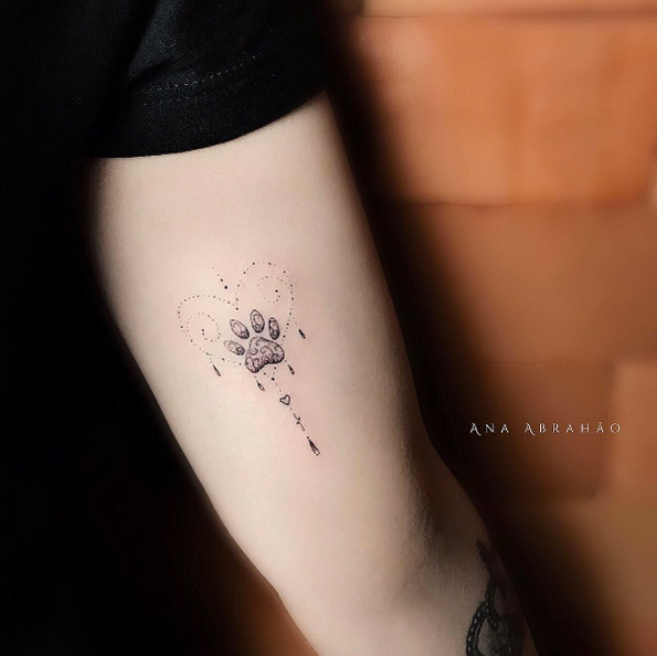 Tiny ornamental paw print tattoo by Ana Abrahao